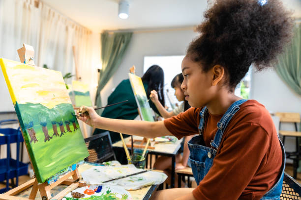 crianças africanas desenhando em sala de aula, menina feliz estudo engraçado e brincar de pintura cor acrílica sobre tela. grupo de crianças desenhando com professor no ateliê escolar. - aula de arte - fotografias e filmes do acervo