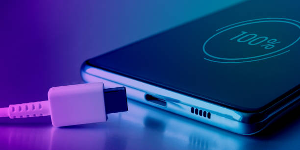 istock Fully charged battery icon on the touch screen of the cell phone and a USB Type-C cable. Fully charged smartphone battery. Keeping the battery intact. Battery safety 1460213512