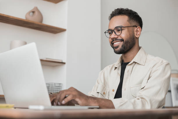 istock Young man using laptop working at home, online meeting, distance studying 1460214499