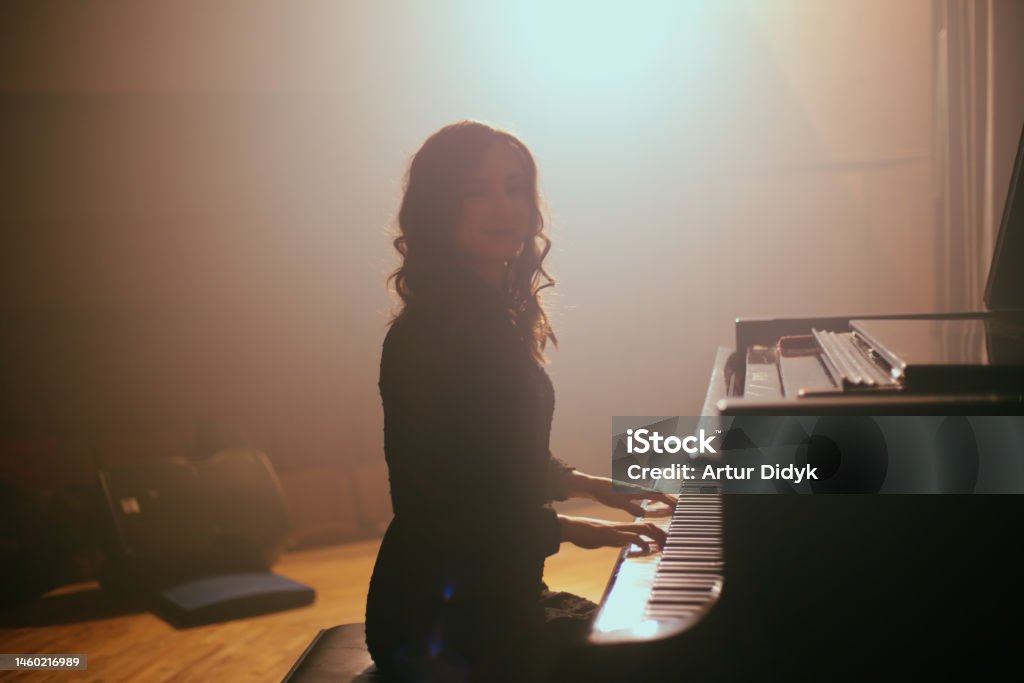 Woman playing the piano theater groups Piano Stock Photo