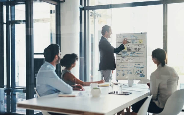 Businessman, meeting and whiteboard notes of workshop, schedule and sales coaching. Mentor writing ideas in team presentation, seminar and planning charts for strategy, brainstorming vision or agenda