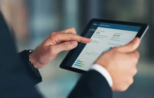 Photo of Analytics, hands or business man with tablet for investment strategy, finance growth or financial review. Digital, search or manager in office for schedule, future data analysis or economy research