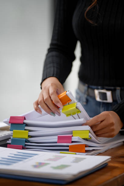 istock Business Documents concept,  woman hands working on Stacks paper files for checking document achieves on folders papers at  office. 1460223133