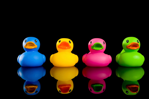 Four brightly colored rubber ducks on a black background.  Note:  Ducks are not copyrighted unless they have a theme
