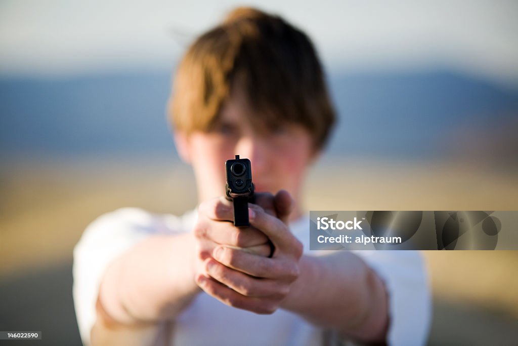 Adolescente Punta pistola di macchina fotografica - Foto stock royalty-free di Arma da fuoco