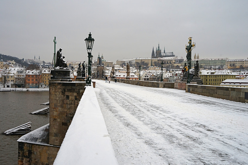 Magical atmosphere on historic Charles Bridge covered with snow in winter season, Prague cityscape, Czech Republic