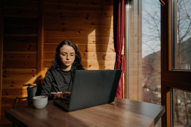 istock Beautiful young woman working from home by the window 1460227609