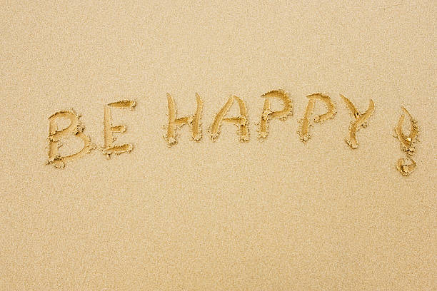 Sandy beach with words Be Happy written on sand stock photo