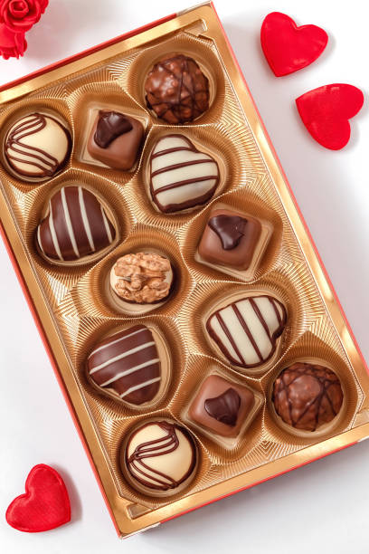 delisious chocolate pralines and red heart for valentine's day. - valentines day candy chocolate candy heart shape imagens e fotografias de stock