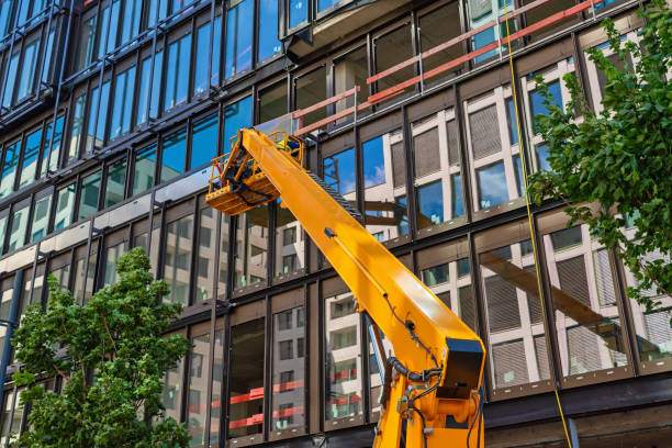 Construction worker using a cherry picker for mounting a Curtain wall facade of a contemporary office building. stock photo
