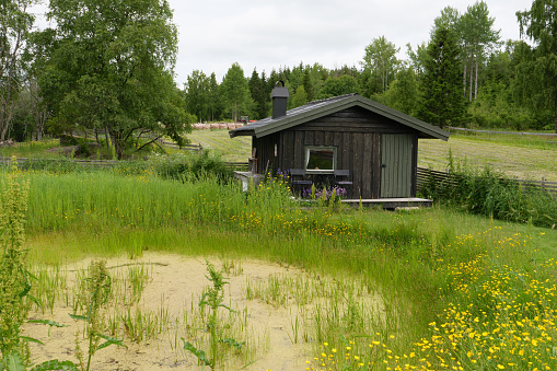 Small hut, pilgrim hostel by a pond. Seen on the pilgrimage path St. Olavsweg near Tangen in Norway province Innlandet.