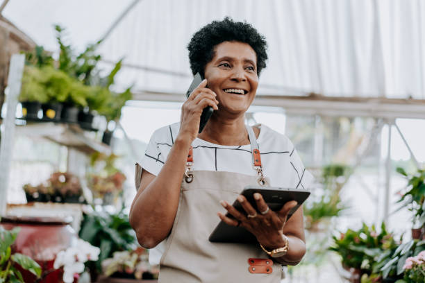 portrait d’un fleuriste vendant par téléphone - florist telephone flower business photos et images de collection