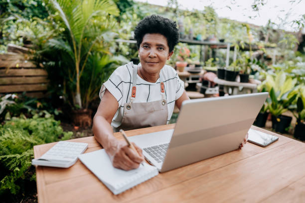 istock Florist woman working on laptop looking at camera 1460234426
