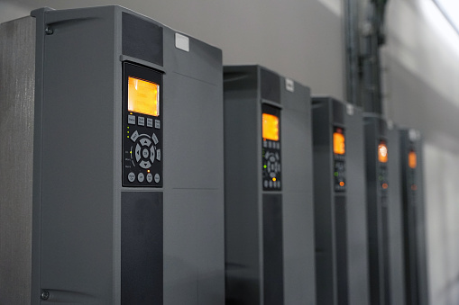 Row of industrial powerful electric inverters used for electric motors, renewable energy concept