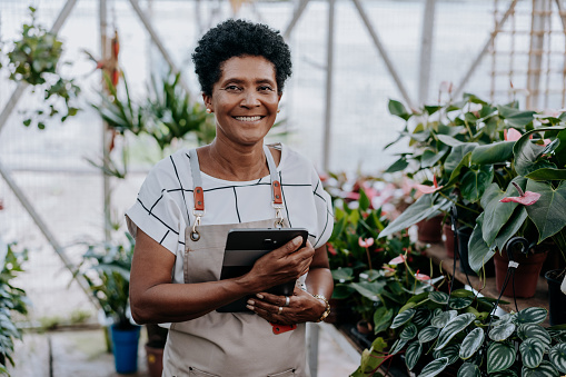 Portrait of a florist looking at camera holding digital tablet
