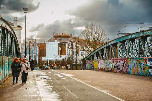 London, UK - 27 January, 2023: people walking on a railway bridge in the Primrose Hill area of London, UK.