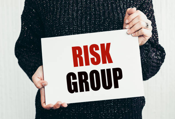 istock Girl holding a card with text RISK GROUP. 1460238760