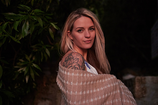 Portrait, towel or night and a woman outdoor on a dark background with mockup for travel or vacation. Tattoo, swimming and nature with an attractive young female posing outside while on holiday