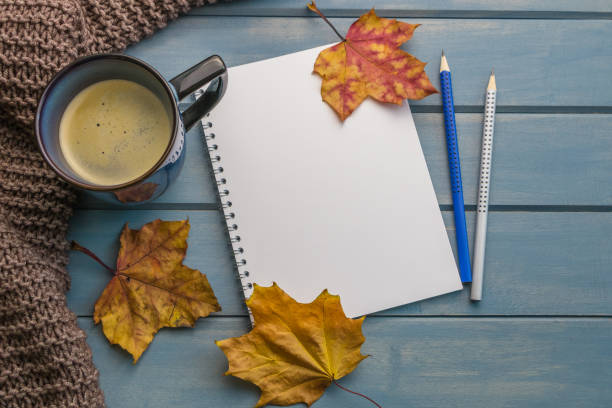 istock Composition with autumn leaves, blank notebooks, a cup of coffee on a blue wooden table 1460239103