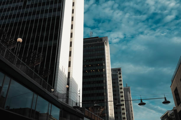 Large and regular clear buildings under sunset sky. Modern architecture and urban life. High white walls.