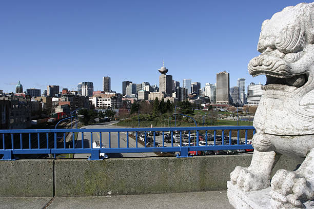 Vancouver Skyline from Seaside park and Chinese lion statues guarding the entrance