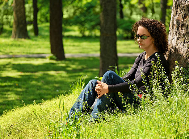 young woman in the park stock photo