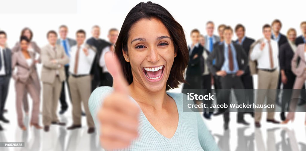 Cheerful businesswoman showing thumbs up with colleagues standing behind her Thumbs Up Stock Photo