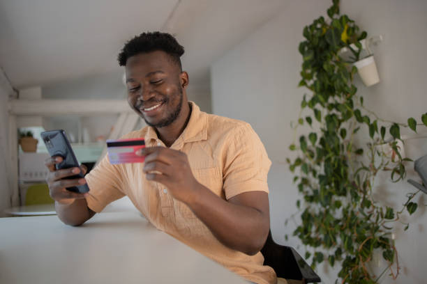 istock Cheerful man doing online shopping 1460260001