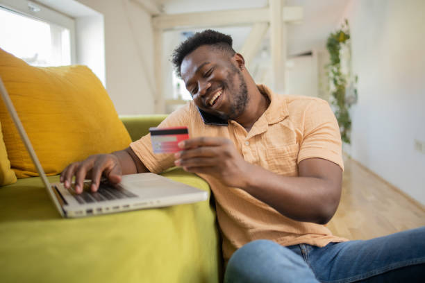 istock Cheerful man doing online shopping 1460260046