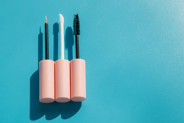 istock pink brushes for cosmetics, mascara, liquid lipstick, eyeliner, lip gloss on a blue background, copy space 1460260450