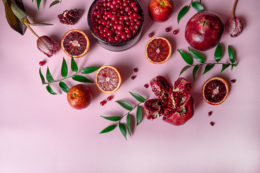 Deliciously Crisp, pomegranate seeds in turquoise bowl & fruits, against dark background, fresh and juicy.