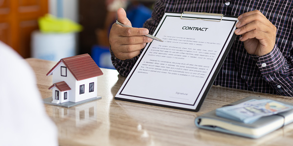 Real estate agents discuss home and land purchases with customers after agreeing to a home purchase and loan agreement.