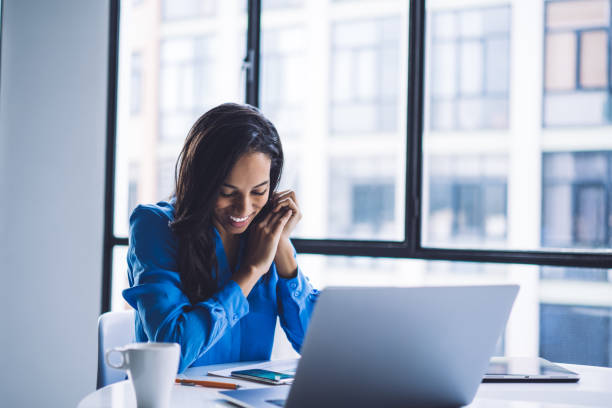 istock Pleased black businesswoman reading message on smartphone while sitting at office table 1460266208