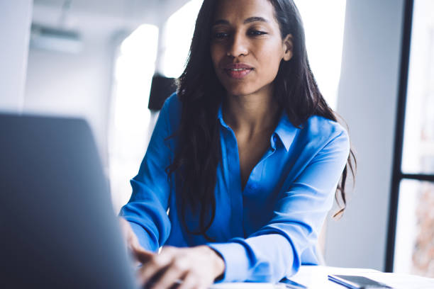 istock Pensive elegant ethnic lady concentrating and working at laptop 1460266239