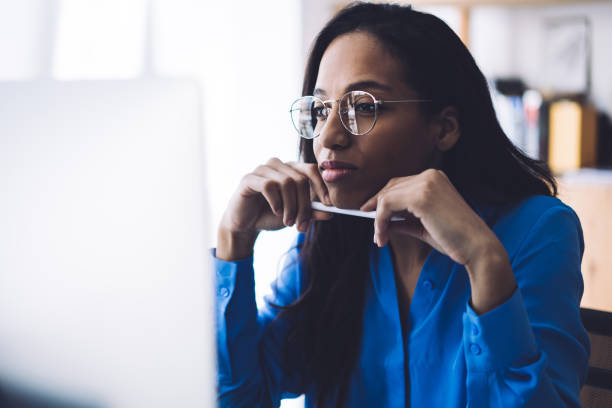 Pensive businesswoman working on computer at office