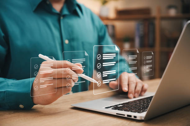 istock Quick checklist and clipboard management concept, businessman working checklist questionnaire assessment form, checking laptop performance and filling out online survey, efficient management. 1460267859