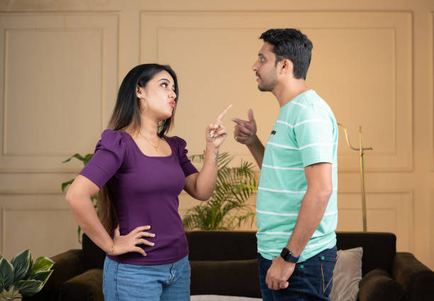 focus on girl, Angry indian couple fighting by shouting eachother while standing at home - concept of relationship problems, conflict and disagreement focus on girl, Angry indian couple fighting by shouting eachother while standing at home - concept of relationship problems, conflict and disagreement divorce india stock pictures, royalty-free photos & images