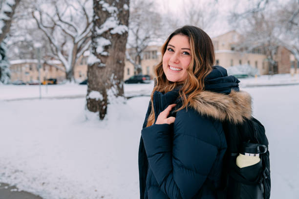 istock Cute Portrait of a Smiling University Student with Backpack Looking Over Her Shoulder at Camera on Campus on a Snowy Day in Colorado 1460270353