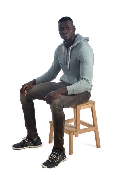 istock portrait of a african man sitting on stool on white background 1460271962