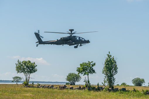 Apache in combat. Helicopter battle training, low flight in natural airfield on Suur-Pakri island, Estonia, Europe.