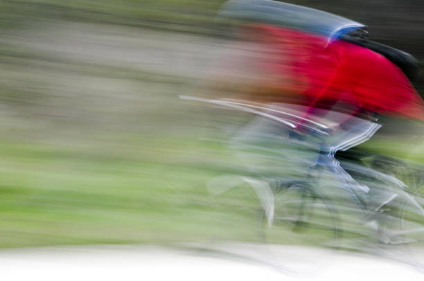 A young man in sweatpants practicing the pan technique while riding a bike