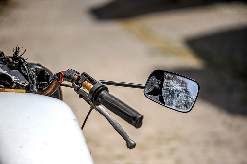 Broken motorcycle and broken rearview mirror