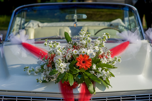 Floral ornaments on a vintage white wedding car
