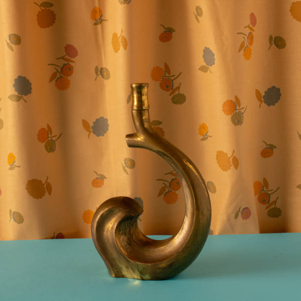 istock Old rustic candlestick ready to use on a blue background and a wall full of various summer flowers 1460279144