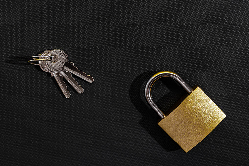 Yellow locked padlock and key on a black background 
Internet security