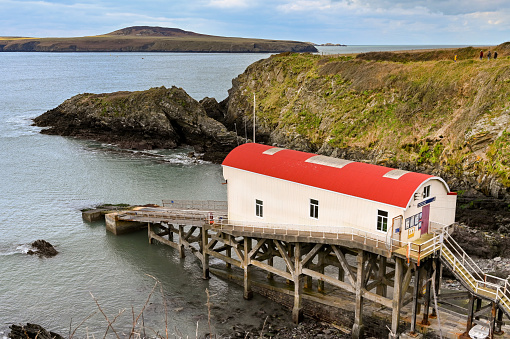 St Davids, Pembrokeshire, Wales - March 2022: Old lifeboat station and slipway on the rocky coast of Pembrokeshire.