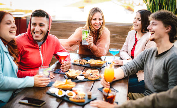 istock Trendy friends sharing multicolored drinks - Young people having fun together drinking cocktails at happy hour - Social gathering and life style concept on vivid filter with focus on middle woman 1460283241