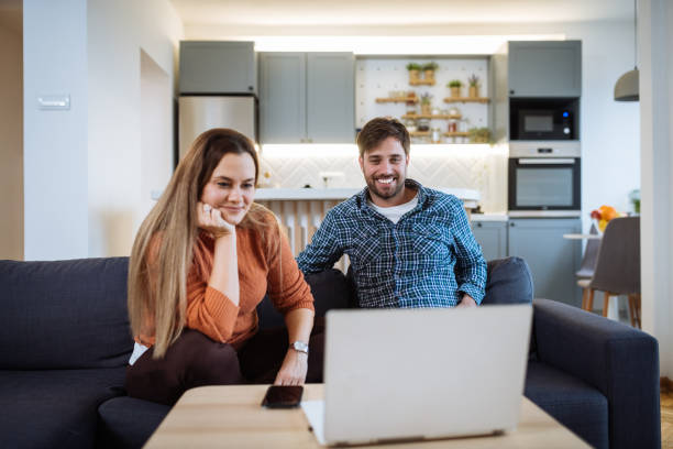 istock Couple using technologies in new apartment, looking at laptop 1460287143