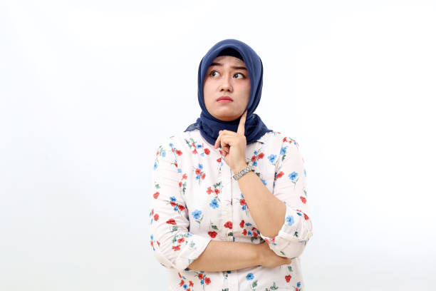 istock Thoughtful asian muslim woman standing while thinking something. Isolated on white background 1460287595