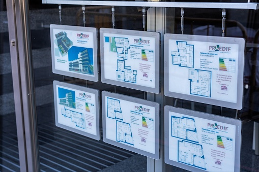 Barcelona, Spain-September 18, 2022. Showcase of a real estate agency with advertisements of flats for sale or rent. Concept of rising mortgage interest rates